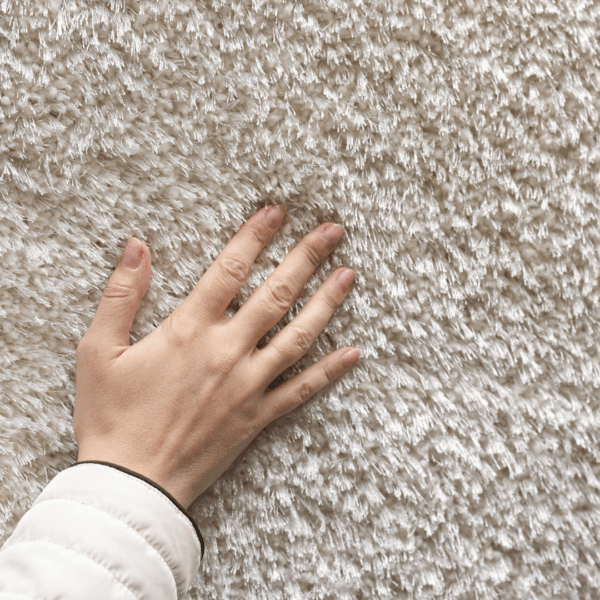 A hand gently touching a soft, textured fabric surface